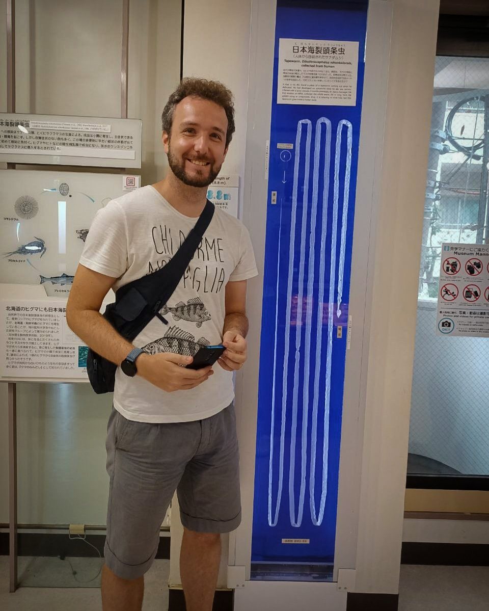 Andrea accanto a una tenia lunga 8,8 metri esposta in museo